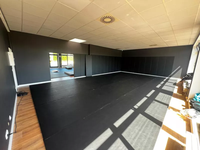 Close‑up of roll‑out mat surface texture and edge detail in a boxing gym setting